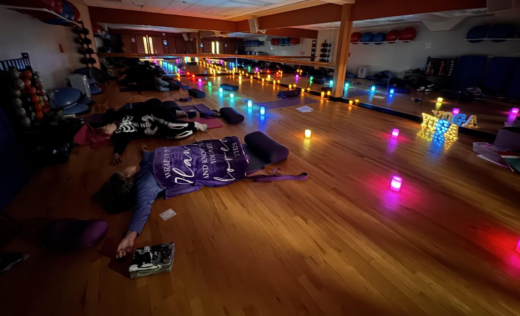 Restorative yoga class with candles, bolsters, blankets, and mats at Mandala Yoga and Bodywork.