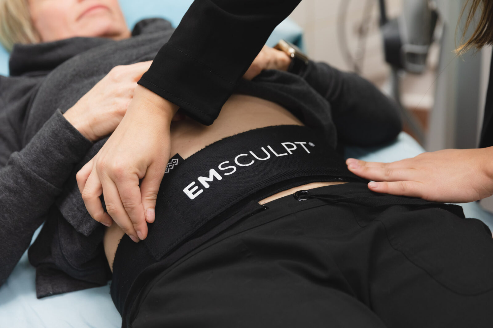 Emsculpt Neo body contouring treatment at CATARA Medical Spa in Algonquin showing the device applicator positioned on a client's abdomen during a non-invasive muscle building and fat reduction session