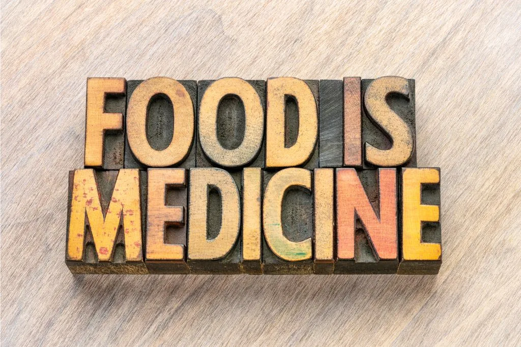 Wood block typography spelling "Food is Medicine" on wooden background, promoting wellness at Catara Med Spa.