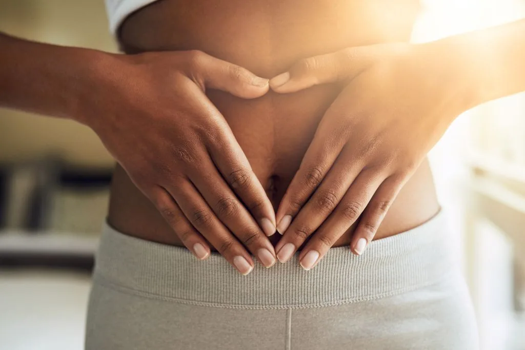 Hands forming a heart over stomach, symbolizing gut health and internal wellness support at Catara Med Spa.